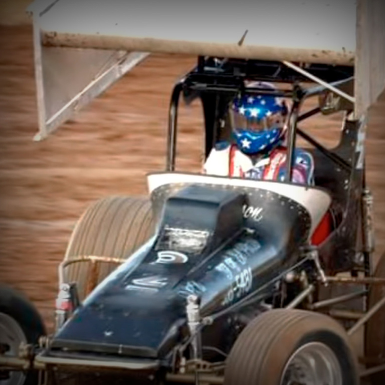 A race car in a dirt track, ready for a ProGlow Powersport car wash.