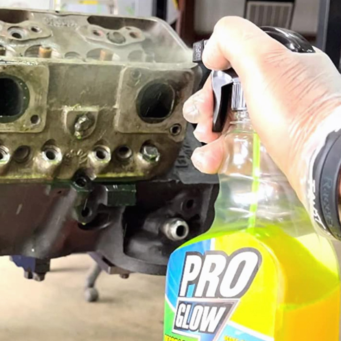 A grimy engine getting sprayed with ProGlow Degreaser.