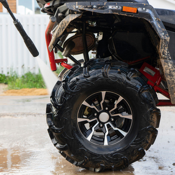 Power washing the mud and dirt off an ATV with ProGlow powersports wash.